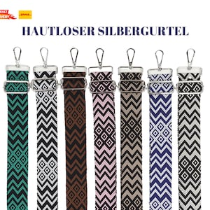 Könnte beinhalten: Sieben verschiedene gemusterte Riemen mit silbernen Verschlüssen. Die Riemen sind aus gewebtem Stoff und haben geometrische Muster in verschiedenen Farben, darunter Schwarz, Weiß, Braun, Rosa, Blau und Grün.