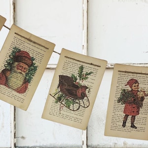 May include: A Christmas banner made from vintage book pages. Each rectangular page features a different holiday-themed illustration, including holly, Santa Claus, a sleigh, and a child holding a Christmas tree. The pages are strung together with twine.