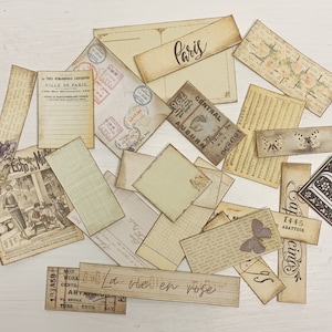 Puede incluir: Una colecci&oacute;n de ef&iacute;meras vintage, incluyendo recortes de papel, boletos y postales, con texto e im&aacute;genes francesas. Las ef&iacute;meras est&aacute;n en varios tonos de marr&oacute;n y crema, algunas con dise&ntilde;os florales. El texto incluye "Par&iacute;s", "La vie en rose" y "Ville de Paris".