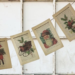Puede incluir: Una guirnalda de p&aacute;ginas de libros antiguos con ilustraciones navide&ntilde;as. Las im&aacute;genes incluyen un ni&ntilde;o, Pap&aacute; Noel, un trineo y acebo. Las p&aacute;ginas est&aacute;n unidas con hilo, creando una decoraci&oacute;n r&uacute;stica para las fiestas.