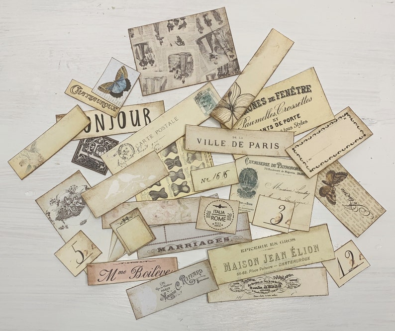 Puede incluir: Una colecci&oacute;n de etiquetas de papel de estilo vintage con varios dise&ntilde;os y textos, incluyendo "Bonjour", "Carte Postale", "Ville de Paris", "Marriages" y "Maison Jean Elion". Las etiquetas son en tonos beige, marr&oacute;n y crema, con algunas que presentan patrones florales y geom&eacute;tricos.