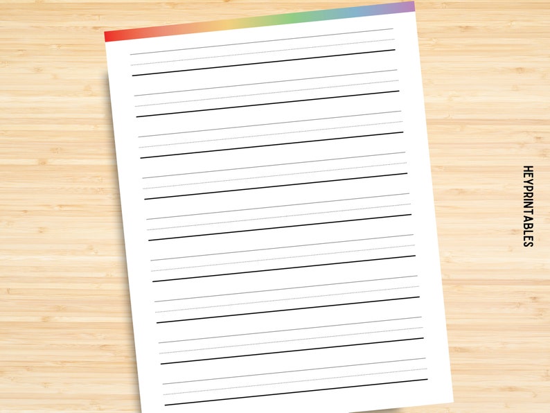 May include: A blank white sheet of paper with black lines, perfect for writing or drawing. The paper has a rainbow colored border at the top.
