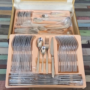 Puede incluir: Un juego de cubiertos de plata en una caja de madera. Los cubiertos incluyen tenedores, cuchillos y cucharas, todos dispuestos ordenadamente en la caja.