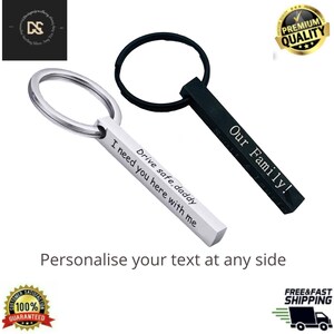 May include: Two personalised keychains with silver and black metal bars. The silver bar reads "Drive safe daddy I need you here with me". The black bar reads "Our Family!".