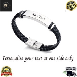 Könnte beinhalten: Ein schwarzes geflochtenes Lederarmband mit einer silbernen Metallplatte, die mit Text personalisiert werden kann. Der Text "Any Text" ist in die Platte graviert.