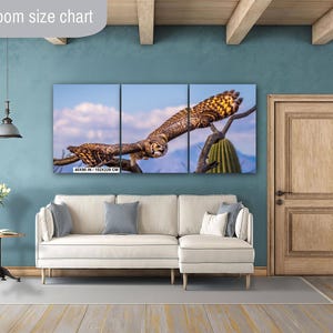 May include: A triptych canvas print featuring a detailed image of an owl in flight. The owl is brown and tan with yellow accents, set against a blue sky and desert landscape. The print measures 40x90 inches (102x229 cm).