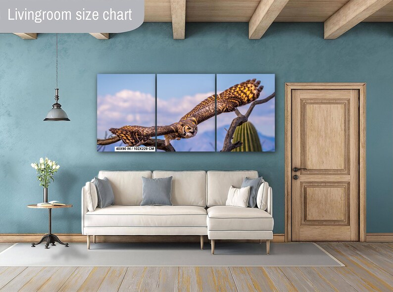 May include: A triptych canvas print featuring a detailed image of an owl in flight. The owl is brown and tan with yellow accents, set against a blue sky and desert landscape. The print measures 40x90 inches (102x229 cm).