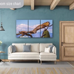May include: A triptych canvas print featuring a detailed image of an owl perched on a tree branch against a blue sky. The artwork is displayed above a white sofa in a living room setting. The print size is 36x72 inches / 91x183 cm.