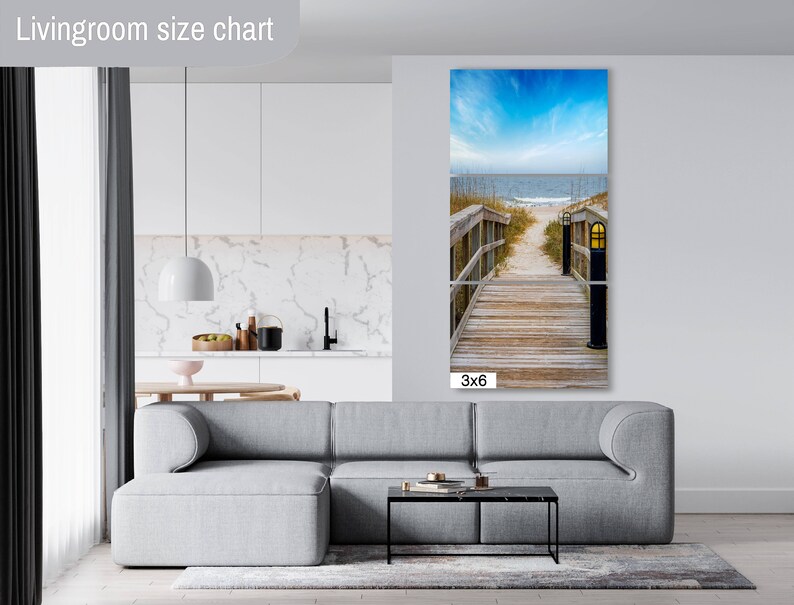 May include: A 3x6 foot canvas print of a wooden walkway leading to a beach with blue sky and ocean in the background. The walkway has a wooden railing and a lamp post on each side.