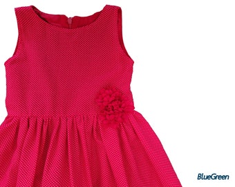 May include: A sleeveless red dress with white polka dots and a red flower accent on the side.