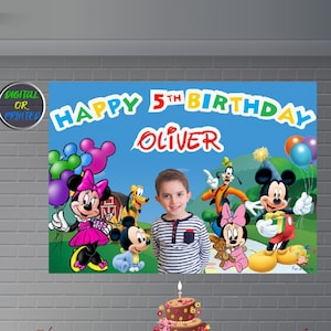 May include: A colorful birthday banner with Mickey Mouse and friends. The banner says "Happy 5th Birthday Oliver".