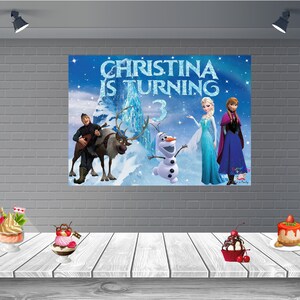Puede incluir: Un tel&oacute;n de fondo de fiesta de cumplea&ntilde;os con tem&aacute;tica de Frozen con Elsa, Anna y Olaf. El tel&oacute;n de fondo es azul con copos de nieve blancos y un castillo en el fondo. El texto "Christina cumple 3 a&ntilde;os" est&aacute; escrito en letras doradas brillantes.