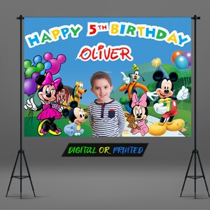 May include: A colorful birthday banner with Mickey Mouse, Minnie Mouse, and Goofy characters. The banner says "Happy 5th Birthday Oliver" and has a blue background with green grass and a red barn.