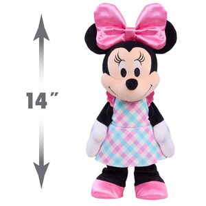 May include: A 14-inch Minnie Mouse plush toy. The plush has a pink bow, a pink and blue checkered dress, and pink shoes. The toy has black ears, arms, and legs, and white gloves.