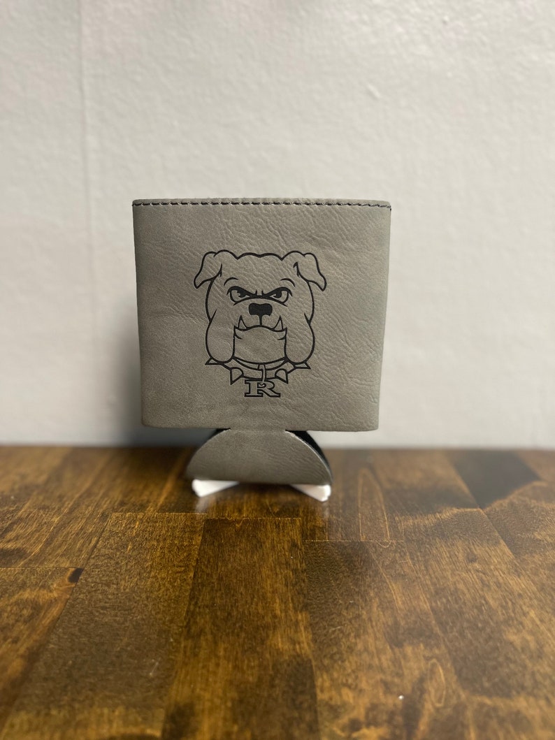 May include: A gray leather can cooler with a black bulldog graphic and the letters "IR" printed on it.