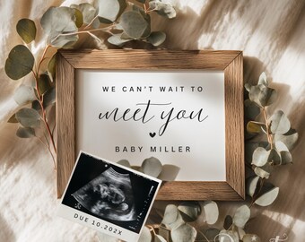 May include: A wooden framed print with the text "WE CAN'T WAIT TO meet you" and "BABY MILLER". An ultrasound image and eucalyptus branches surround the frame. The due date is printed on the ultrasound image.