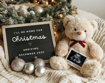 May include: A neutral-toned teddy bear with a red bow sits next to an ultrasound image and a letter board. The letter board reads "I'll be home for Christmas" and "Arriving December 202X". Silver ornaments and greenery complete the festive scene.
