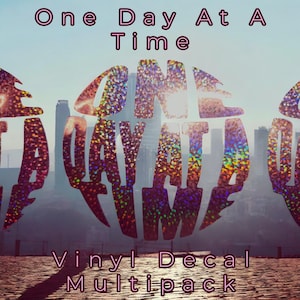 May include: A multipack of vinyl decals featuring the words "One Day At A Time" in a holographic, rainbow-like finish. The decals are set against a backdrop of a city skyline.
