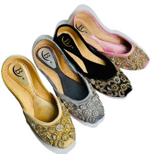 May include: Four pairs of embroidered velvet flats in pink, black, gray, and beige. Each pair has a gold embroidered design and a label with the letter "B" inside a circle.