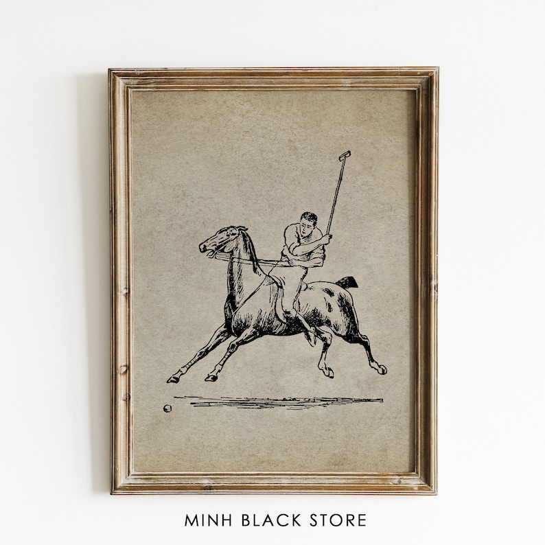 May include: A framed vintage print with a black and white illustration of a polo player on horseback. The artwork shows the player swinging a mallet at a ball. The frame is light brown. The text "MINH BLACK STORE" is at the bottom of the print.