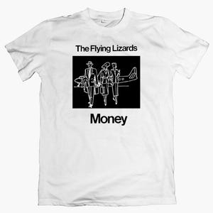 Op de afbeelding: Wit T-shirt met een zwart-witte afbeelding. De afbeelding toont de tekst "The Flying Lizards" boven een rechthoekige afbeelding van drie mensen en een vliegtuig, met het woord "Money" eronder.