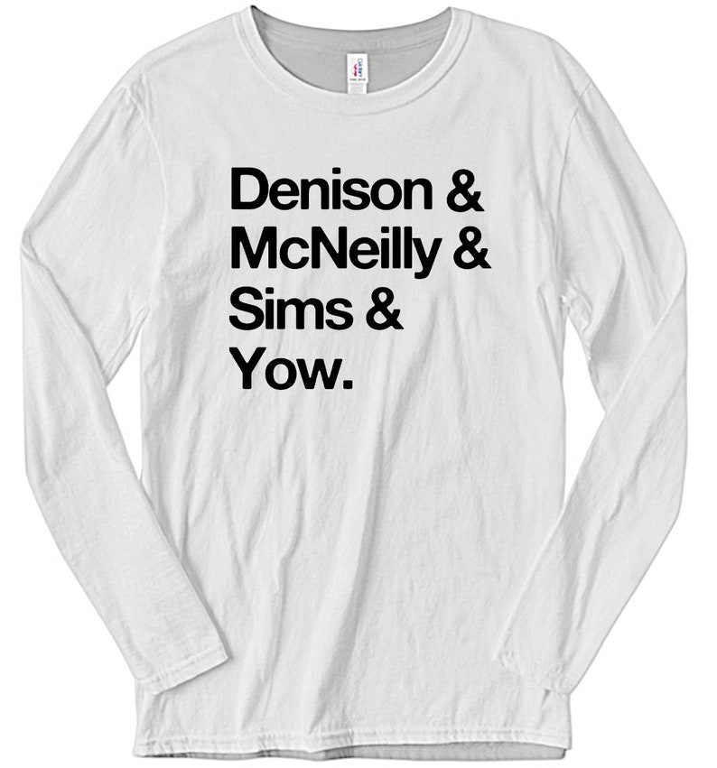 May include: White long-sleeve t-shirt with black text that reads "Denison & McNeilly & Sims & Yow."