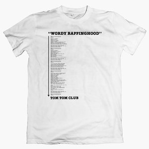 Puede incluir: Camiseta blanca con texto negro que dice "WORDY RAPPINGHOOD" y una larga lista de palabras. En la parte inferior de la camiseta, se lee "TOM TOM CLUB".