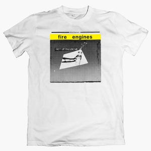 May include: White t-shirt featuring a graphic design. The design includes the words "fire engines" in a yellow and black banner, with the text "GET UP and USE ME" below. The graphic is in black and white.