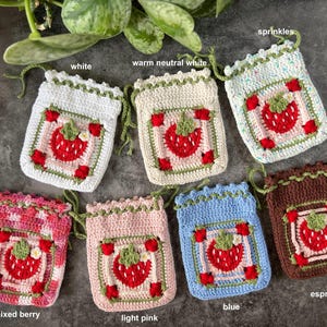 Może przedstawiać: Siedem szydełkowych woreczków ze sznurkiem do ściągania z motywami truskawek w różnych kolorach, w tym białym, ciepłym neutralnym białym, posypką, mieszanką jagód, jasnoróżowym, niebieskim i espresso.