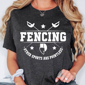 May include: A dark gray t-shirt with a white graphic design. The graphic features two crossed fencing swords, a star, and the text "Fencing. Other sports are pointless."