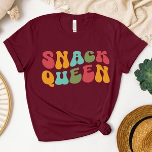 a t - shirt with the words snack queen printed on it