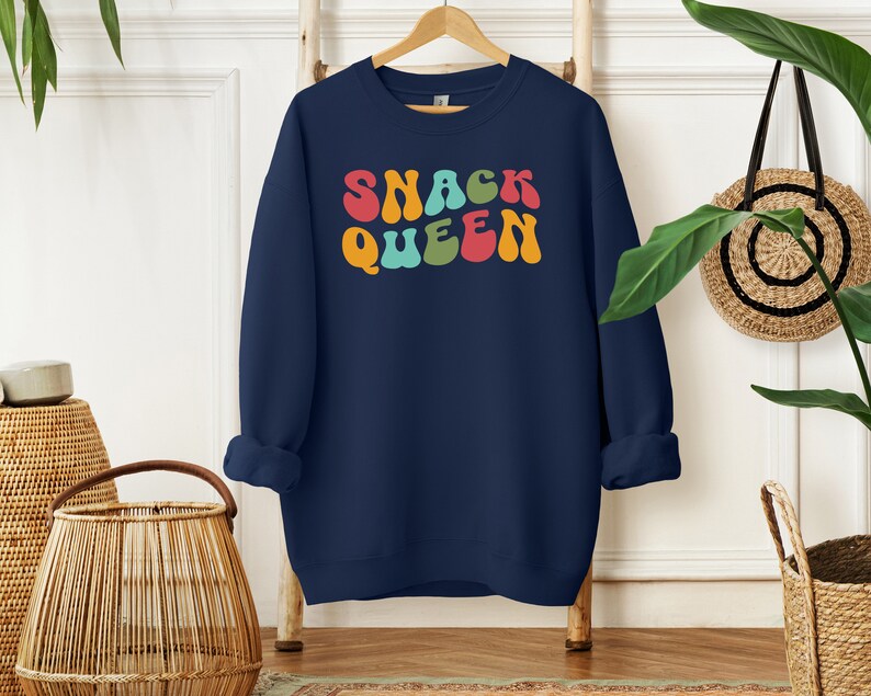 a blue sweatshirt with the words snack queen printed on it
