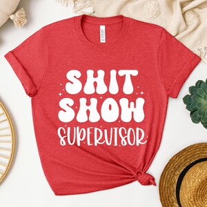 a red shirt that says shit show supervisor