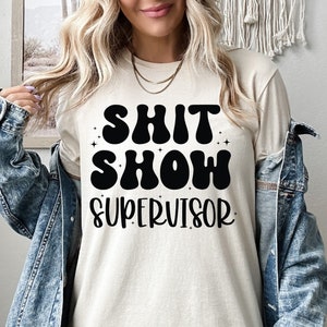 a woman wearing a shirt that says shit show supervisor