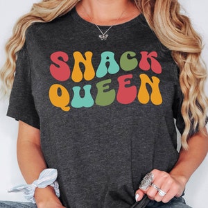a woman wearing a t - shirt that says snack queen