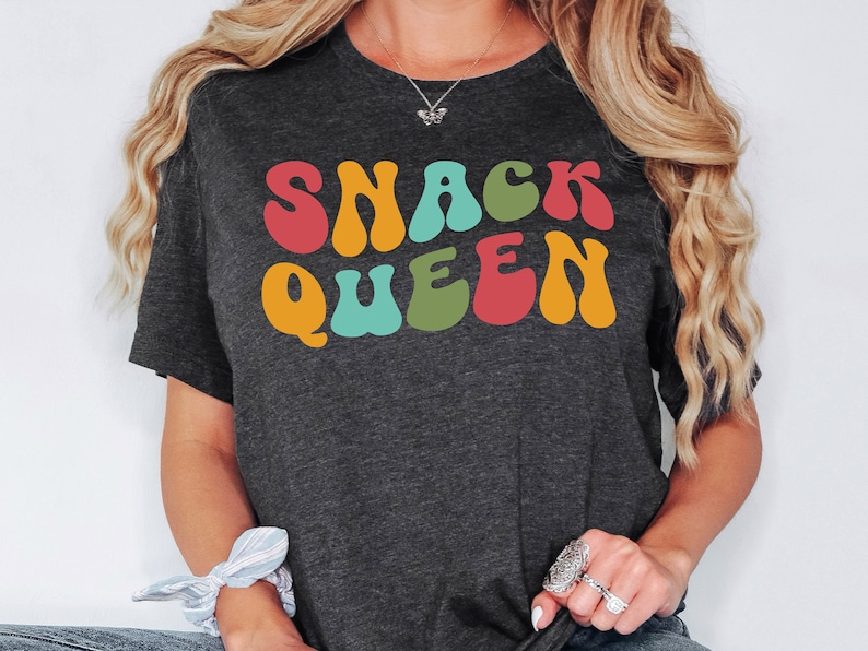 a woman wearing a t - shirt that says snack queen