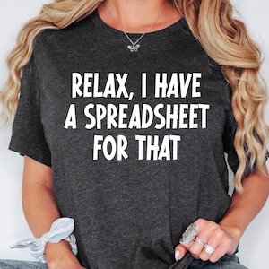 May include: A dark gray t-shirt with the text "Relax, I have a spreadsheet for that" in white.