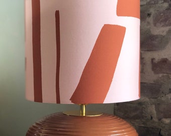 Table lamp made of terracotta base with graphic lampshade in brown and light salmon