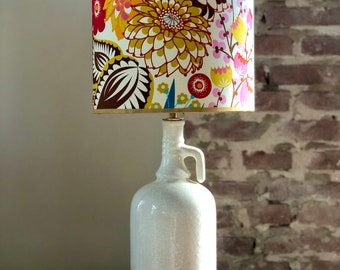 Table lamp made of ceramic white jug, shade with floral pattern trimmed with gold chintz trim, brass details.