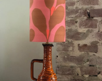 Table lamp in 60s or 70s style with a modern touch, made of an orange jug. Retro vintage design.