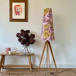 Vloerlamp met 4 eikenhouten poten en conische kap in lichtroze, bruin en geel. 170cm hoog.