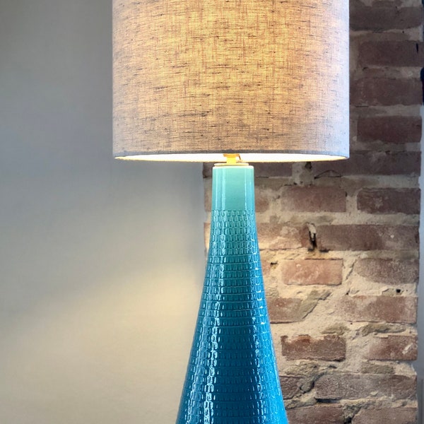 Grande lampe de table composée d'un vase en céramique bleu aqua et d'un abat-jour en lin beige. Ambiance plage !