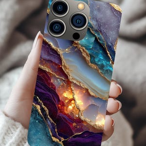 May include: A smartphone case with a vibrant, abstract design. The case features a blend of blue, purple, and gold colors, resembling a geode or agate stone. The case has a glossy finish and a camera module with three lenses.