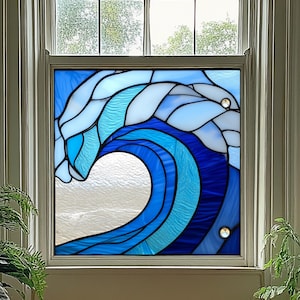 May include: Stained glass window panel depicting a stylized ocean wave in shades of blue and white. The wave design features curved lines and textured glass, with a clear, open space at the wave's crest. Two decorative crystal accents are visible.