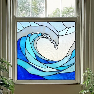 May include: Stained glass window panel depicting a stylized ocean wave. The wave is rendered in shades of blue and white, with a curved crest and flowing lines. The panel is framed in a white window, with greenery visible outside.
