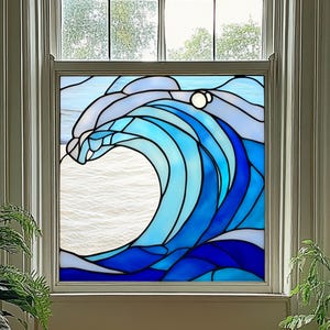 May include: Stained glass window panel featuring a stylized ocean wave design. The wave is depicted in shades of blue, with white accents, and a white background suggesting the sea. The panel is set in a white window frame.