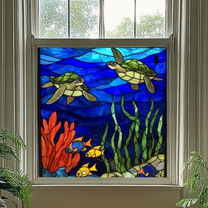 May include: Stained glass window panel featuring an underwater scene. Two green sea turtles swim in a deep blue ocean with stylized waves. Orange coral, yellow fish, and green seaweed add color. The panel is framed in a white window.
