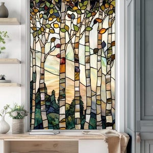 Puede incluir: Una ventana de vitrales que representa una escena de bosque con árboles altos y delgados con hojas de colores y una puesta de sol en el fondo.