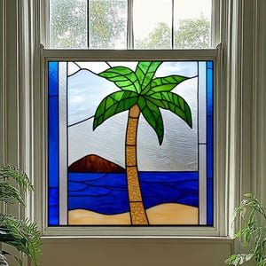 Könnte beinhalten: Buntglasfenster mit einer tropischen Szene. Eine grüne Palme mit braunem Stamm steht an einem Sandstrand, mit blauem Ozean und einer braunen Insel im Hintergrund. Der Himmel ist hellblau.