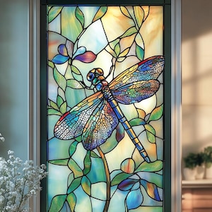 Puede incluir: Una ventana de vitral con una libélula colorida con alas azules, verdes y amarillas, posada sobre un tallo con hojas verdes. La libélula está rodeada de un diseño floral con flores moradas y azules.